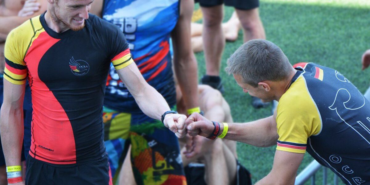 Zwei Athleten der OCRA Germany motivieren sich mit einem Fist Bump